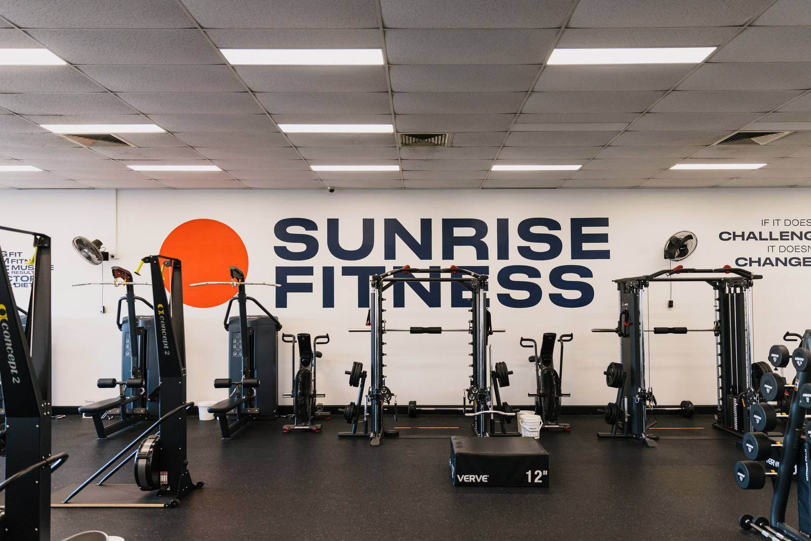 Wide view of the studio floor with the Sunrise Fitness mural