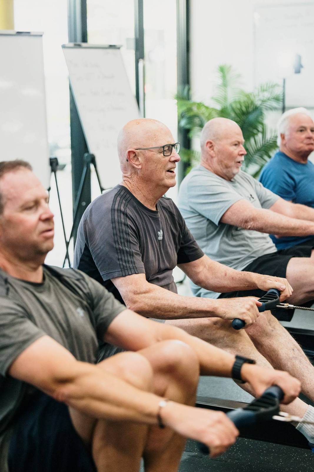 A row of members mid-stroke on Concept2 rowers