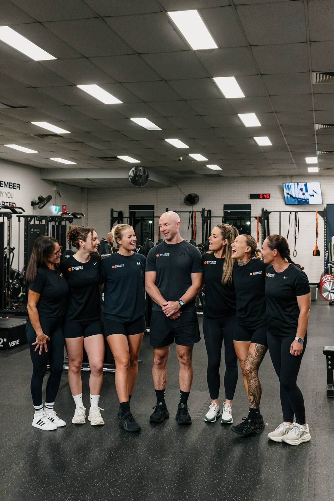 The Sunrise Fitness coaching team shares a laugh on the gym floor