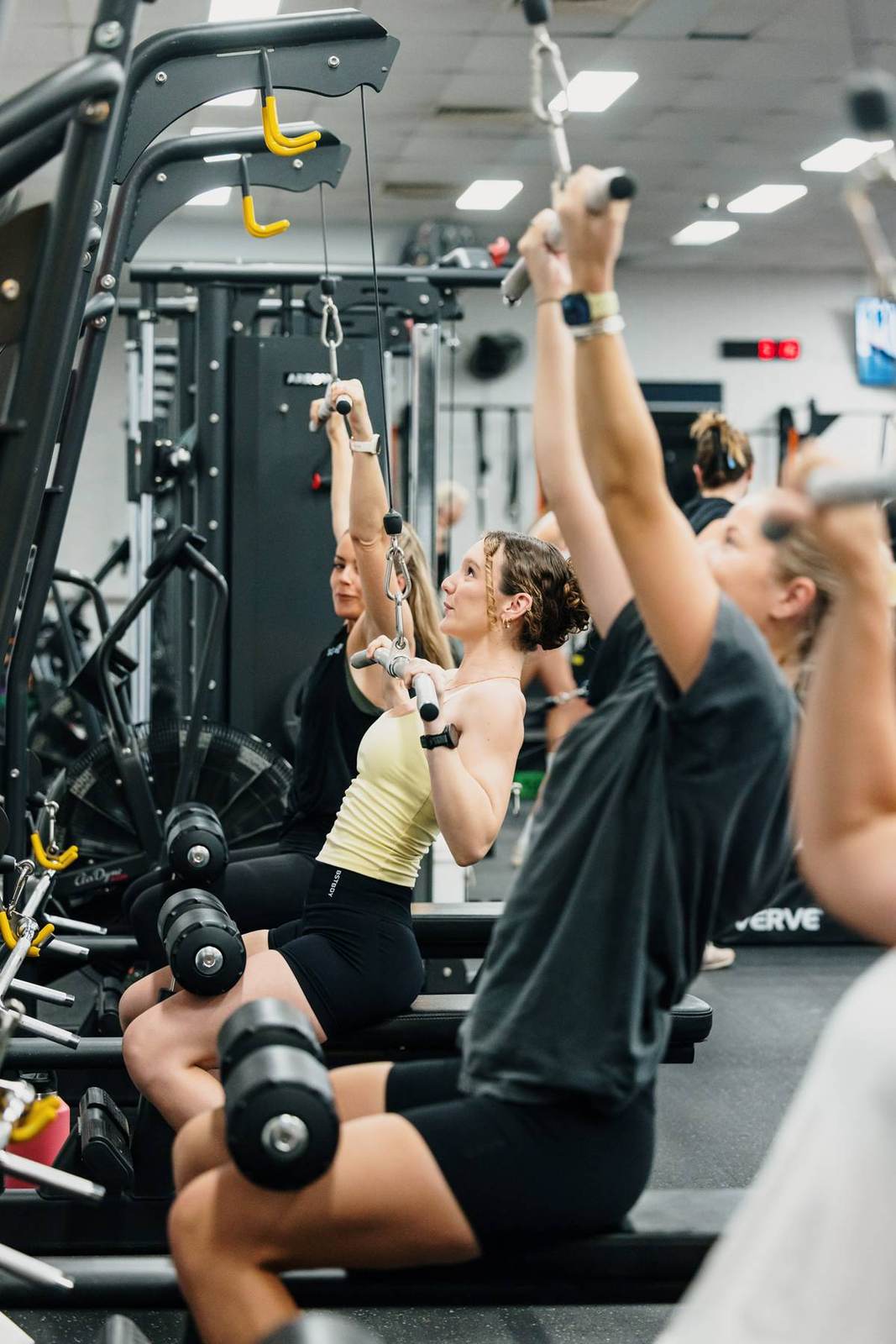 Members work through a lat pulldown station together
