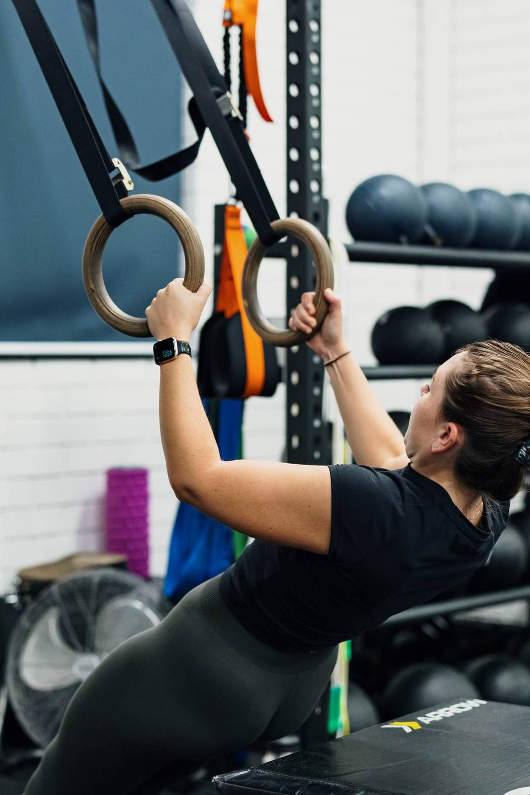 A member pulls on gymnastic rings during a functional session